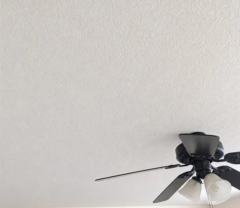 Repaired textured drywall ceiling after patching and texture matching